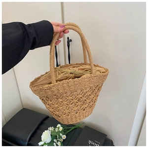 Detail of hand-woven straw bucket bag featuring a hollow design and secure inner drawstring
