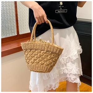 Detail showing the woven mesh layer and drawstring inner lining of this straw handbag