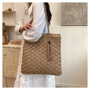 Close-up of bohemian woven tote bag with fringe tassels and intricate crochet texture