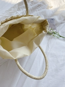 Top view of handmade straw bag showing spacious interior with cream fabric lining