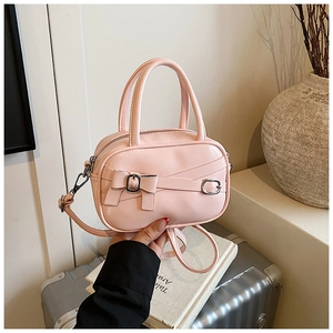 Pink mini crossbody bag featuring a decorative bow and silver hardware detail