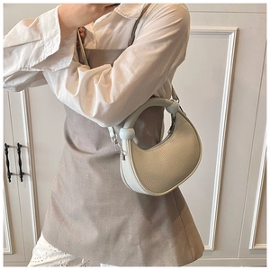 Detail of off-white crescent bag featuring lychee grain texture and round handle