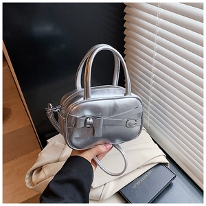 Detail of silver metallic handbag with bow accent and leather strap decoration