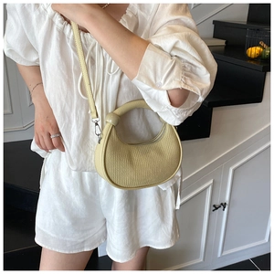 Detail of light green pleated handbag showing vertical texture and cylindrical handle