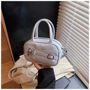 Detail of light blue crossbody bag with ribbon bow and elegant top handle design