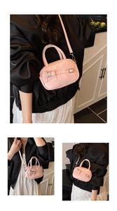Pink glossy leather crossbody bag with decorative bow and metal buckle details