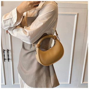 Detail of khaki crescent bag featuring woven texture and wooden bead handle accents