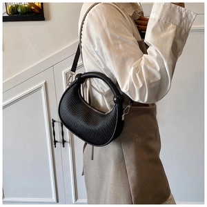 Detail of black crescent moon handbag with vertical embossing and circular handle