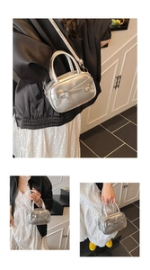 Detail of silver metallic handbag showing structured bow and buckle with crossbody strap
