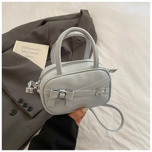 Detail of light blue Boston handbag with bow decoration and adjustable shoulder strap