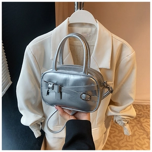 Detail showing metallic silver handbag with metal buckle and adjustable shoulder strap