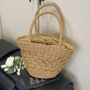 Minimalist straw handbag with hollow weave, round handles, and internal drawstring pouch