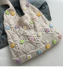 Détail du sac à main tricoté au crochet avec fleurs colorées en résine 3D sur denim