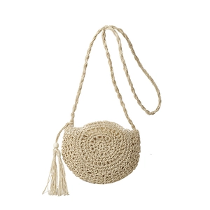 Minimalist hand-woven round straw crossbody bag with tassels and shoulder strap in beige
