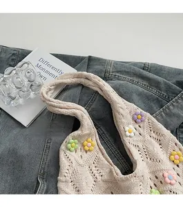Détail du sac tricoté beige ajouré orné de fleurs de soleil 3D colorées au crochet