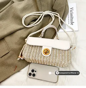 Detail of woven straw handbag with gold clasp compared to iPhone 12 for size