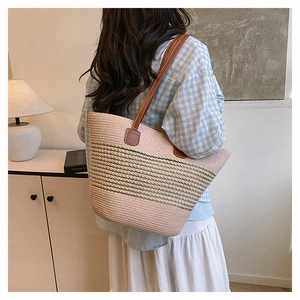 Close-up of pink striped woven tote bag with brown leather shoulder straps