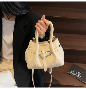 Detailed close-up of cream lychee pattern leather handbag with adjustable strap