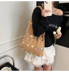 Détail du sac cabas en maille crochetée avec breloques fleurs 3D et texture tissée