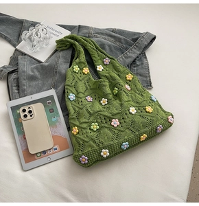 Détail du sac cabas en tricot vert avec fleurs colorées et texture de losanges ajourés