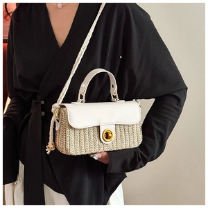 Detail of summer woven square bag featuring a gold twist lock and white rope shoulder strap