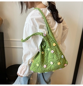 Gros plan du sac à bandoulière en tricot vert avec fleurs 3D et motif au crochet doux