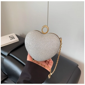 Détail d'un sac de soirée pailleté en forme de cœur avec fermoir anneau doré