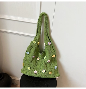 Gros plan sur un sac cabas en tricot vert avec décorations florales 3D colorées