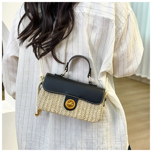 Detail of woven straw handbag with black leather flap and golden round buckle