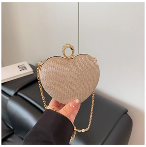 Détail de la pochette de soirée en forme de cœur dorée avec poignée en strass