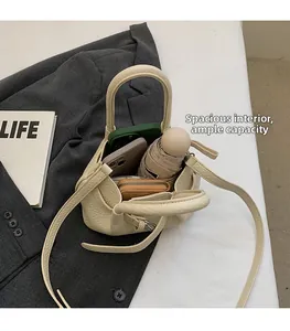 Spacious interior of beige lychee leather crossbody bag holding two phones and an umbrella