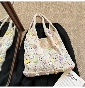 Détail d'un sac en maille avec fleurs 3D et motif de tricot ondulé ajouré
