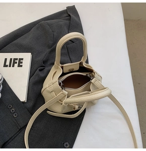 Top view of cream lychee texture bucket bag with silver hardware and inner zipper pocket