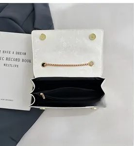 Detail showing white snake-patterned bag interior with a functional zipper compartment