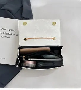 Detailed interior of a white snakeskin crossbody bag showing makeup storage and compartments