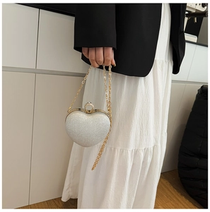 Détail de la pochette de soirée en forme de cœur argenté avec texture pailletée