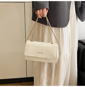 Detail of ivory chain shoulder bag with fine textured faux leather and gold strap