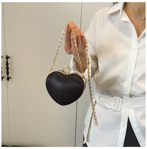 Détail de la pochette de soirée pailletée en cœur avec fermoir anneau cristal et chaîne