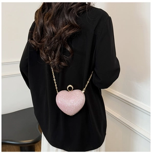 Détail du sac de soirée cœur pailleté rose avec poignée strass et chaîne dorée
