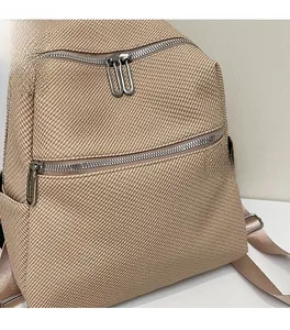 Close-up of khaki woven texture and silver dual zippers on this large commute backpack