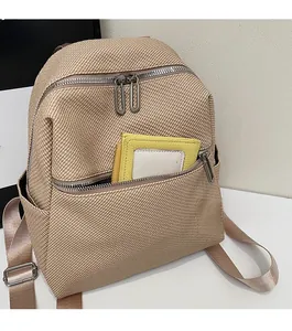 Close-up of a woven backpack's front zipper pocket storing a yellow coin purse