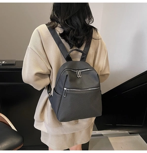 Detail of a black large-capacity commute backpack with woven texture on a model's back