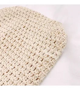 Close-up of the intricate honeycomb knit pattern on a beige woven shoulder bag