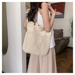 Detail of cream woven tote bag featuring high-quality cotton texture and leather straps