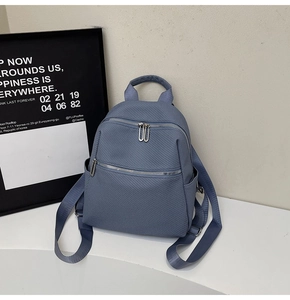 Detail view of the blue woven texture and dual zipper design of the large backpack