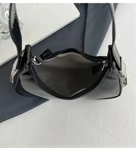 Vue de dessus du sac hobo en cuir verni noir montrant l'intérieur spacieux et la doublure