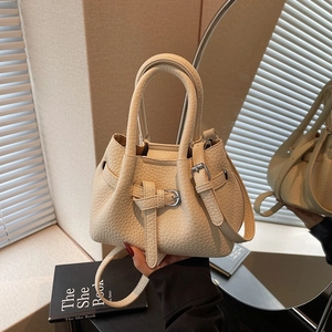 Chic beige lychee leather bucket bag with top handle and metal buckle strap detail
