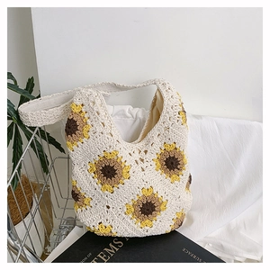 Détail d'un sac cabas au crochet avec motif de tournesol et fleurs artisanales brodées