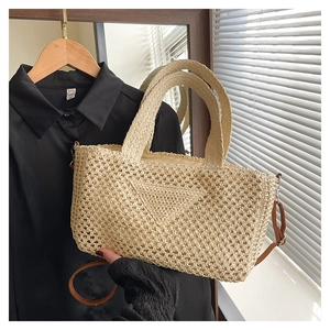 Close-up of beige woven tote bag with triangular pattern and brown shoulder strap