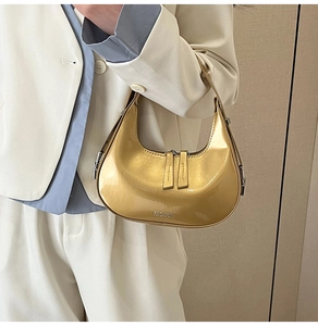 Vue détaillée du sac hobo doré métallisé porté avec un blazer blanc pour un look chic